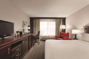 麦迪逊卡尔森麦迪逊乡村套房酒店 的酒店客房配有一张床、一张书桌和一台电视。