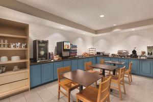 麦迪逊卡尔森麦迪逊乡村套房酒店 的厨房配有蓝色橱柜和木桌及椅子