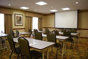 罗杰斯南本顿维尔套房江山宾馆的一间会议室,配有桌椅和屏幕