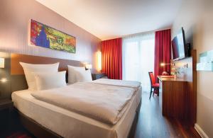 德累斯顿德累斯顿老城莱昂纳多酒店的酒店客房设有一张大床和一张书桌。