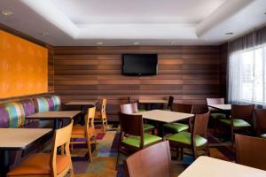 凤凰城卡尔森江山旅馆 - 凤凰城机场的餐厅设有桌椅和平面电视。
