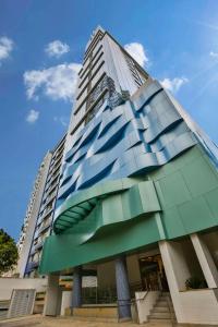 桑托斯Park Inn by Radisson Santos的一座高大的玻璃建筑,背后是蓝天