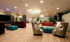 奥克兰奥克兰机场丽筠酒店的大堂配有沙发、椅子和壁炉