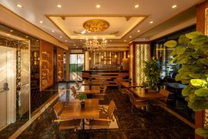 伊斯坦布尔金色之梦酒店的餐厅设有木桌、椅子和吊灯。