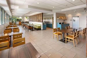 米拉梅萨北圣地亚哥乡村套房酒店的一间带桌椅的餐厅和一间自助餐厅