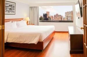 波哥大Radisson Bogota Metrotel的一间设有大床和窗户的酒店客房