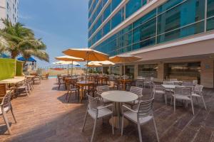卡塔赫纳Radisson Cartagena Ocean Pavillion Hotel的室外餐厅设有桌椅和遮阳伞。