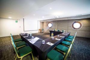 康康Radisson Blu Acqua Hotel & Spa Concon的一间会议室,配有长桌和绿色椅子