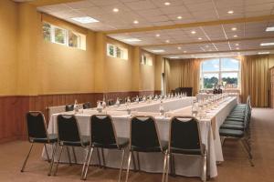 巴拉斯港巴拉斯港丽筠酒店的大型会议室,配有长桌子和椅子