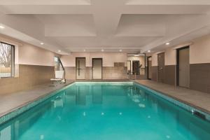 贝尔维尔Country Inn & Suites by Radisson, Belleville, ON的大楼内的一个蓝色海水游泳池