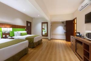 圣何塞圣何塞机场江山套房度假村的酒店客房设有两张床和一台平面电视。