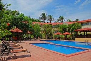 圣何塞圣何塞机场江山套房度假村的一个带躺椅的游泳池和一间酒店