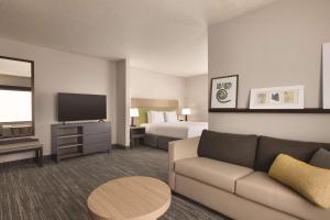 坦帕Country Inn & Suites by Radisson, Tampa Airport East-RJ Stadium的酒店客房设有一张沙发和一张床