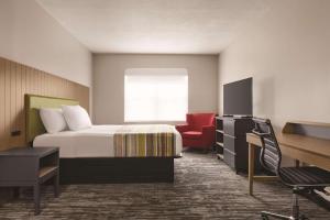 巴拿马城巴拿马城卡尔森江山旅馆的酒店客房,配有一张床和一张红色椅子