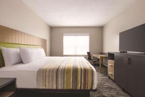 巴拿马城巴拿马城卡尔森江山旅馆的酒店客房配有一张床、一张书桌和一台电视。