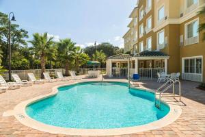 珀特奥兰治佛罗里达州橘子港代顿雷迪森乡村套房酒店 的一座带椅子的游泳池以及一座建筑