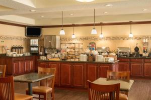 珀特奥兰治佛罗里达州橘子港代顿雷迪森乡村套房酒店 的一个带木制橱柜和桌椅的大厨房