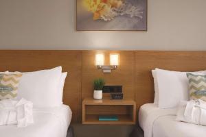 巴拿马城海滩Radisson Panama City Beach - Oceanfront的酒店客房设有两张床和一张带时钟的桌子。