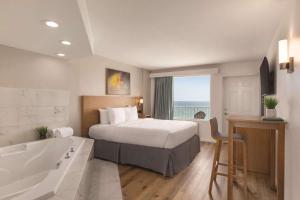 巴拿马城海滩Radisson Panama City Beach - Oceanfront的酒店客房配有一张床和浴缸。