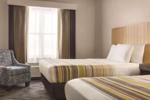 巴拿马城海滩卡尔森巴拿马城市海滩乡村套房酒店的酒店客房带两张床、椅子和窗户