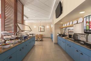 奥兰多Country Inn & Suites by Radisson, Orlando Airport, FL的餐厅内带蓝色橱柜的大厨房