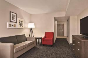 坦帕坦帕江山旅馆及套房的带沙发和红色椅子的客厅
