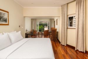 内罗毕Fairview Hotel Nairobi的卧室配有一张白色大床和一张书桌
