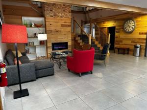 哥伦布Country Inn & Suites by Radisson, Columbus, GA的带沙发和红色椅子的客厅