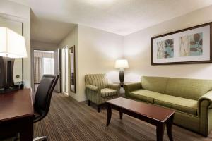 金斯兰金斯兰江山旅馆&套房酒店的酒店客房设有一间带沙发和椅子的客厅