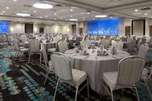 克拉尔维尔珊瑚村丽筠酒店及会议中心 - 爱荷华市的宴会厅配有桌椅和屏幕