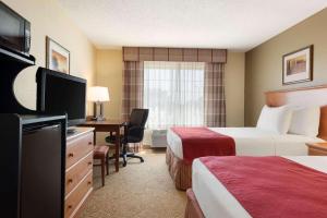 达文波特乡村酒店及套房由卡尔森 - 达文波特管理的酒店客房设有两张床和一张书桌及电视