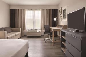 锡达福尔斯卡尔森苏福尔斯江山旅馆的酒店客房配有一张床和一张书桌及一台电视