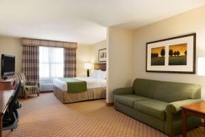 皮奥里亚Country Inn & Suites by Radisson, Peoria North, IL的酒店客房,配有床和沙发