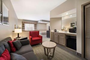 弗里波特Country Inn & Suites by Radisson, Freeport, IL的带沙发和红色椅子的客厅