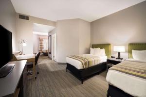 弗里波特Country Inn & Suites by Radisson, Freeport, IL的酒店客房配有两张床和一张书桌