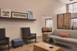 伦敦Country Inn & Suites by Radisson, London, KY的客厅配有沙发和两把椅子