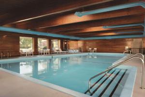 特拉弗斯城乡村旅馆及特拉弗斯城套房酒店的一个带桌椅的大型游泳池