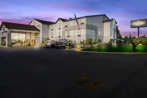 格兰维尔Country Inn & Suites by Radisson, Grandville-Grand Rapids West, MI的一座大型建筑,前面有汽车停放