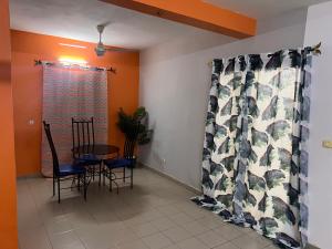 瓦加杜古Ouedraogo Property Management的一间带桌椅和窗户的用餐室