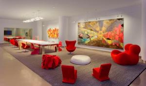布卢明顿美国商场丽笙酒店的一间设有红色椅子、桌子和绘画的房间