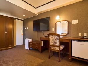 甲贺水口世纪酒店的酒店客房配有书桌和镜子