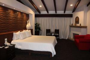 瓜达拉哈拉Radisson Hotel Tapatio Guadalajara的酒店客房,配有一张床和一张红色的沙发