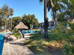 瓜达拉哈拉Radisson Hotel Tapatio Guadalajara的一个带桌子和树木的游泳池的度假酒店