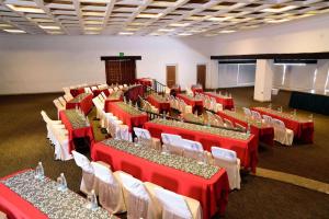 瓜达拉哈拉Radisson Hotel Tapatio Guadalajara的宴会厅配有红色桌子和白色椅子