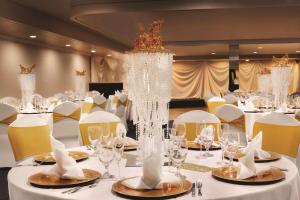 夏洛特夏洛特机场雷迪森酒店的一间设有白色桌椅和大吊灯的房间