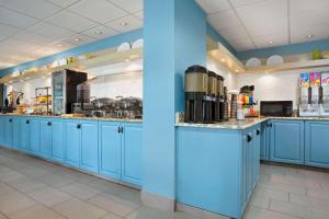 夏洛特夏洛特大学江山旅馆与套房酒店的一间设有蓝色橱柜和电器的大厨房