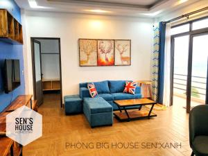SenHomestay的客厅配有蓝色的沙发和桌子