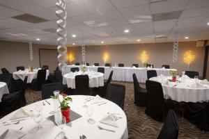 法戈法戈卡尔森江山旅馆&套房酒店的宴会厅配有白色桌子和黑色椅子