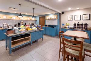 法戈法戈卡尔森江山旅馆&套房酒店的厨房配有蓝色橱柜和一张带食物的桌子