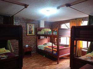 巴尼奥斯Hostal D´Mathias的带两张双层床和砖墙的客房